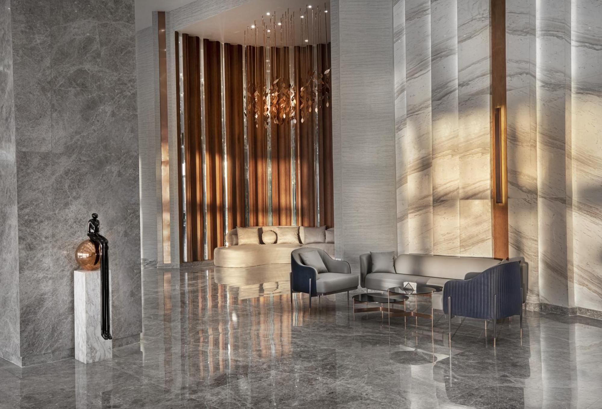 V Hotel Sharm El Shiekh Exterior photo The photo depicts a modern interior space, likely a lobby or lounge, characterized by a sleek and elegant design. The floor has a polished, reflective surface, enhancing the spaciousness of the area. 

To one side, there are vertical wooden panels th
